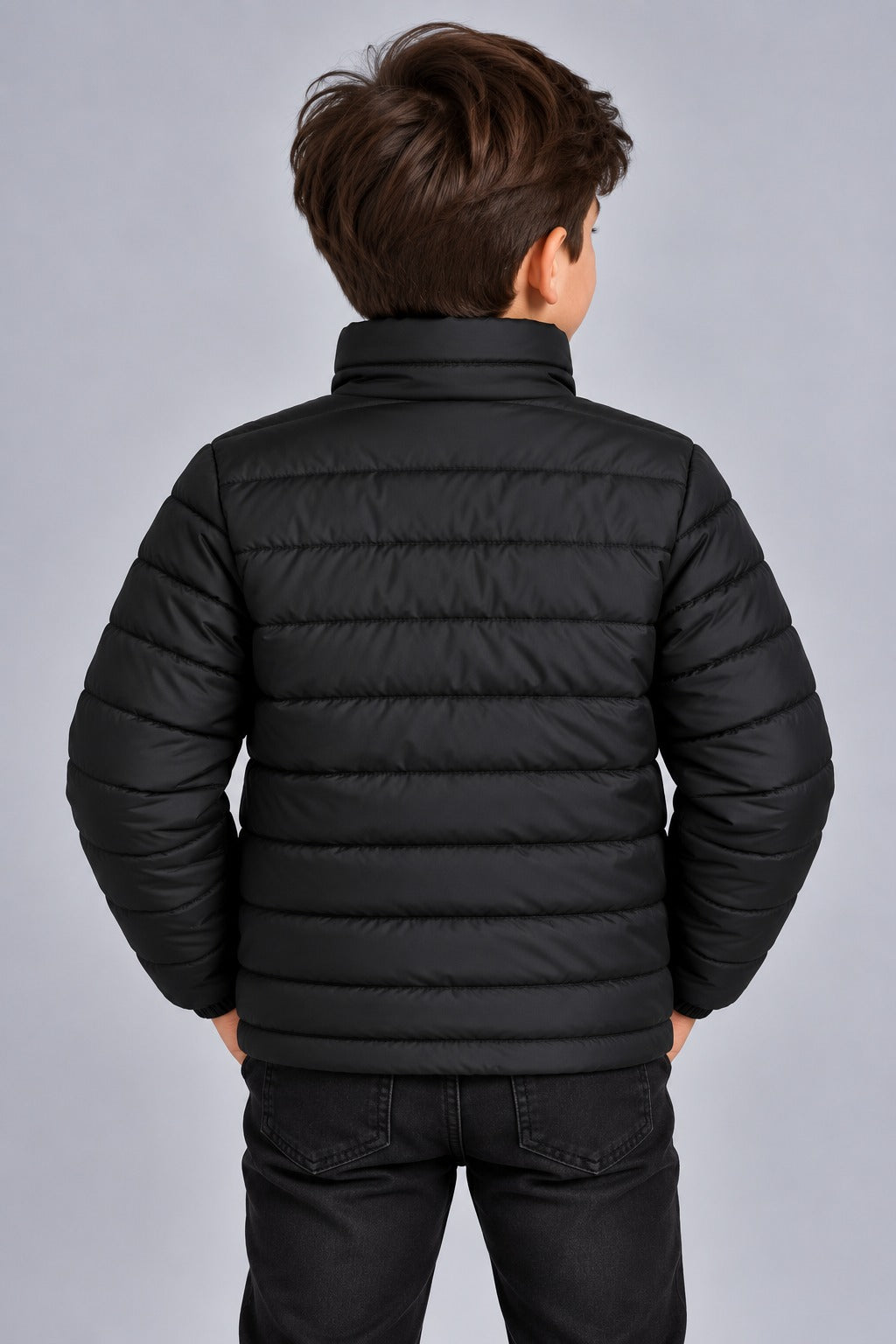 Young boy wearing black horizontal quilted winter puffer jacket back view