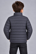 Young boy wearing charcoal grey horizontal quilted winter puffer jacket back view