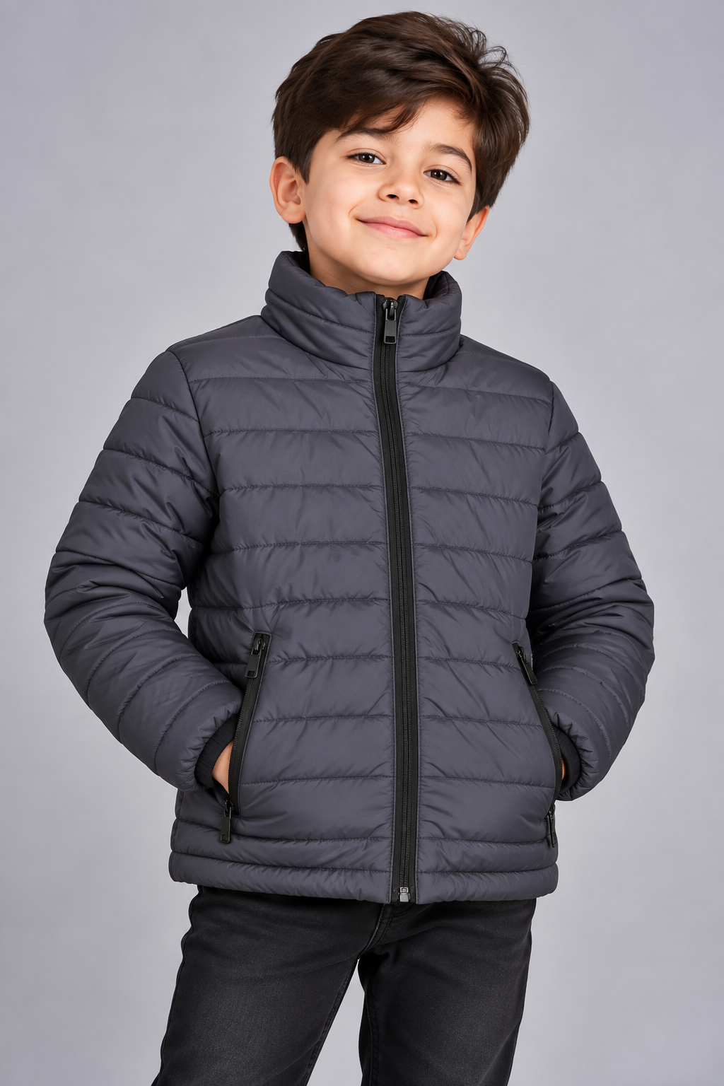 Young boy wearing charcoal grey lightweight quilted puffer jacket front view with zip closure