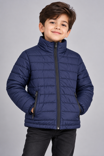 Young boy wearing navy blue lightweight quilted puffer jacket front view with zip closure