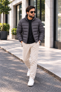 Man wearing charcoal grey lightweight quilted puffer jacket street style front view walking outside