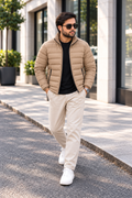 Man wearing khaki beige lightweight quilted puffer jacket street style front view walking outside