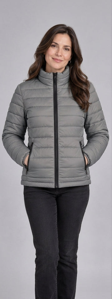 Woman wearing light grey lightweight quilted puffer jacket front view with zip closure and stand collar