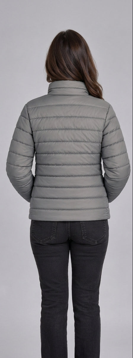 Woman wearing light grey lightweight quilted puffer jacket front view with zip closure and stand collar