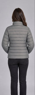 Woman wearing light grey horizontal quilted winter puffer jacket clean back view